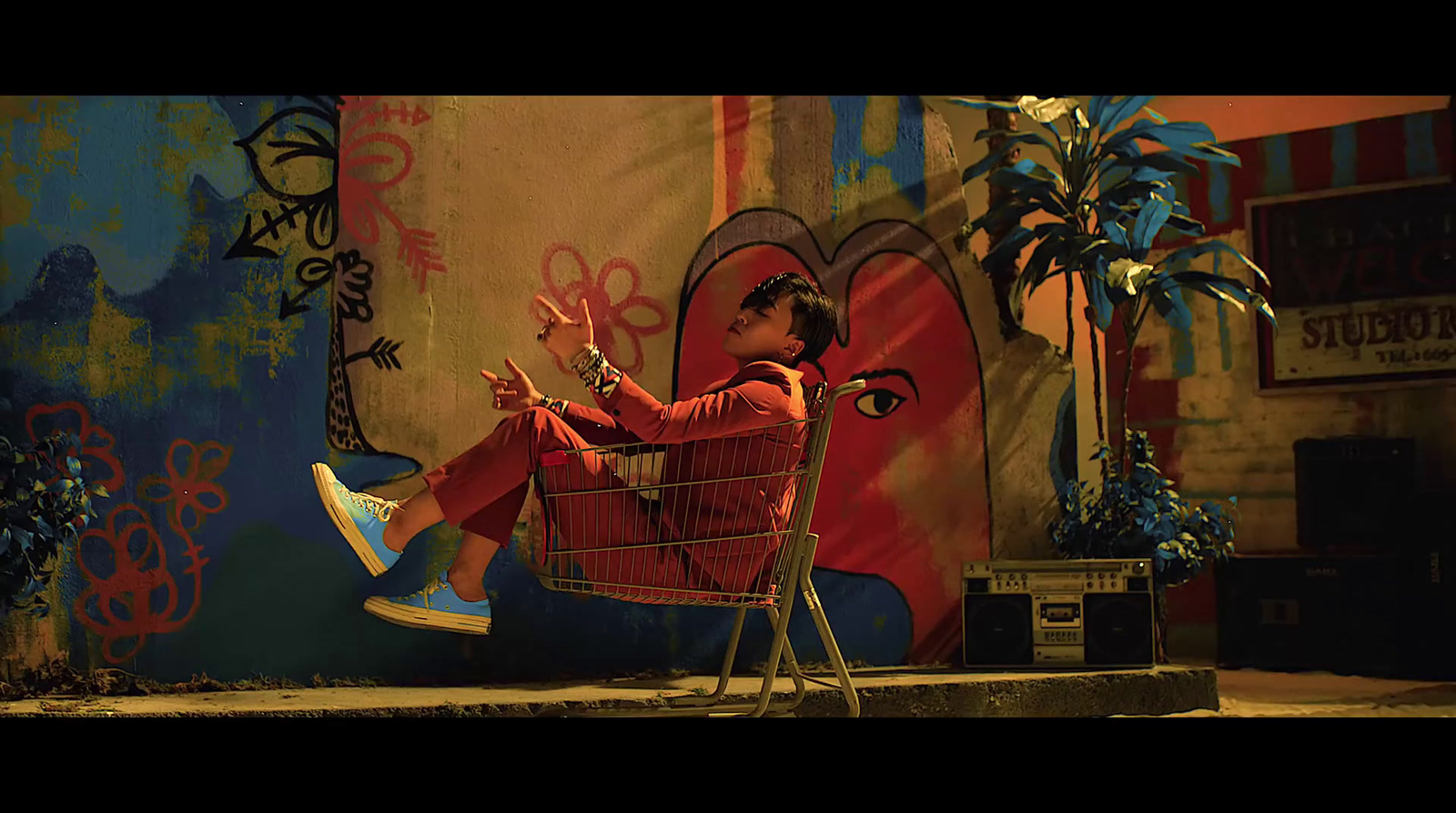 a person sitting in a shopping cart in front of a wall