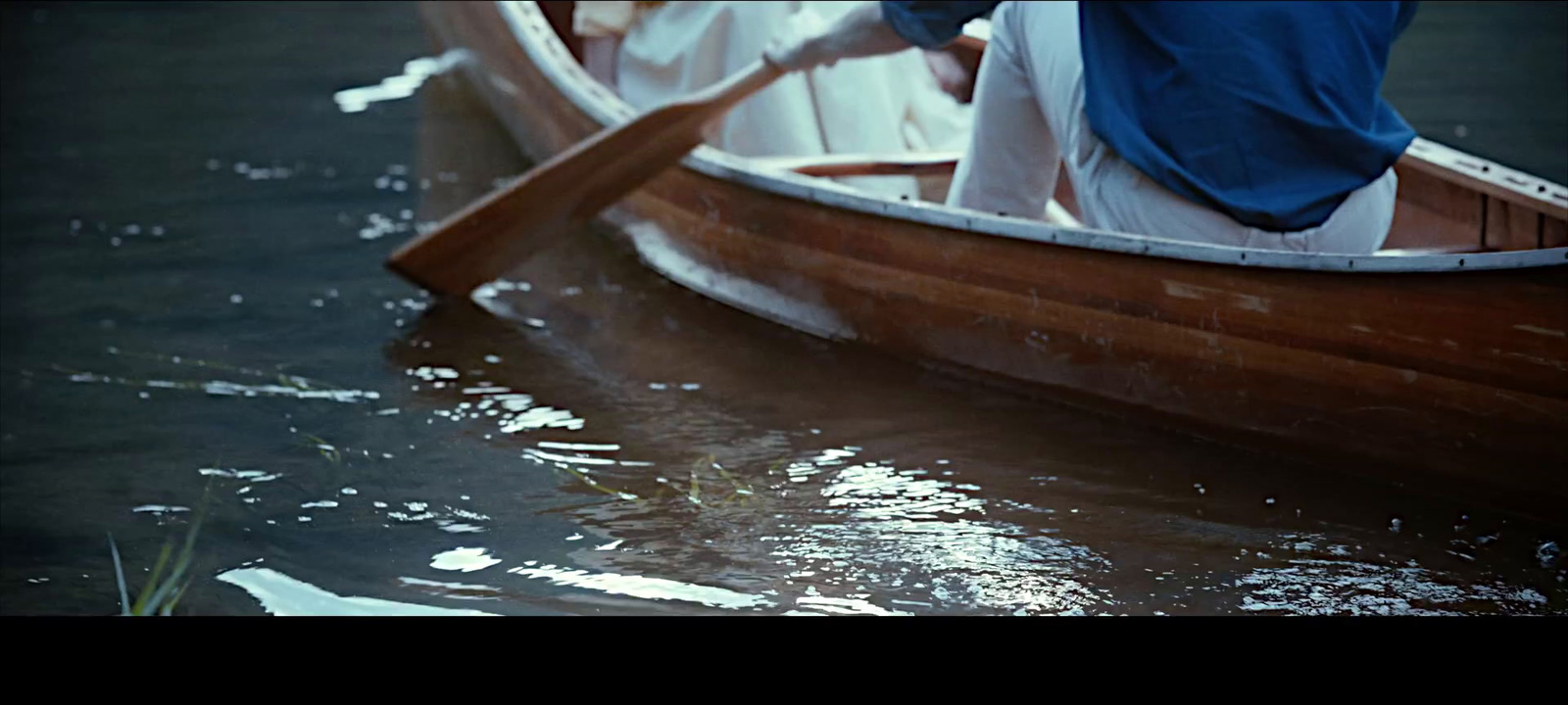 two people in a row boat on a body of water