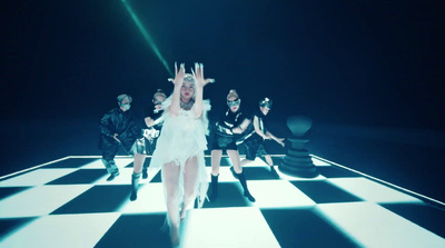 a woman in a white dress dancing on a checkered floor