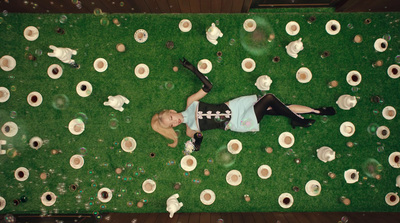 a woman laying on top of a lush green field