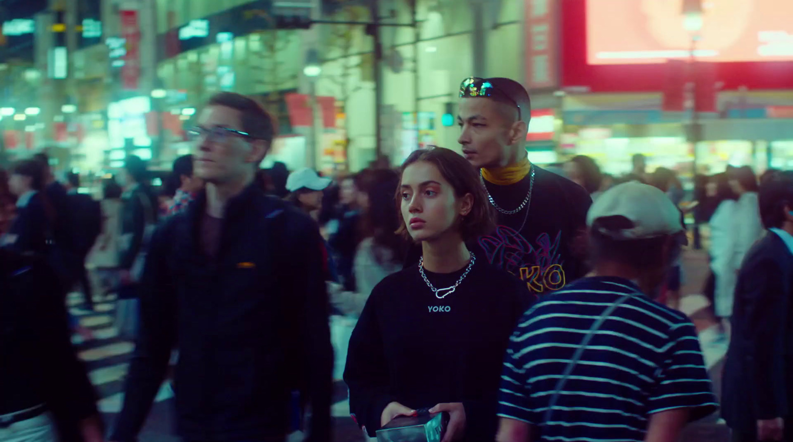 a group of people walking down a street at night