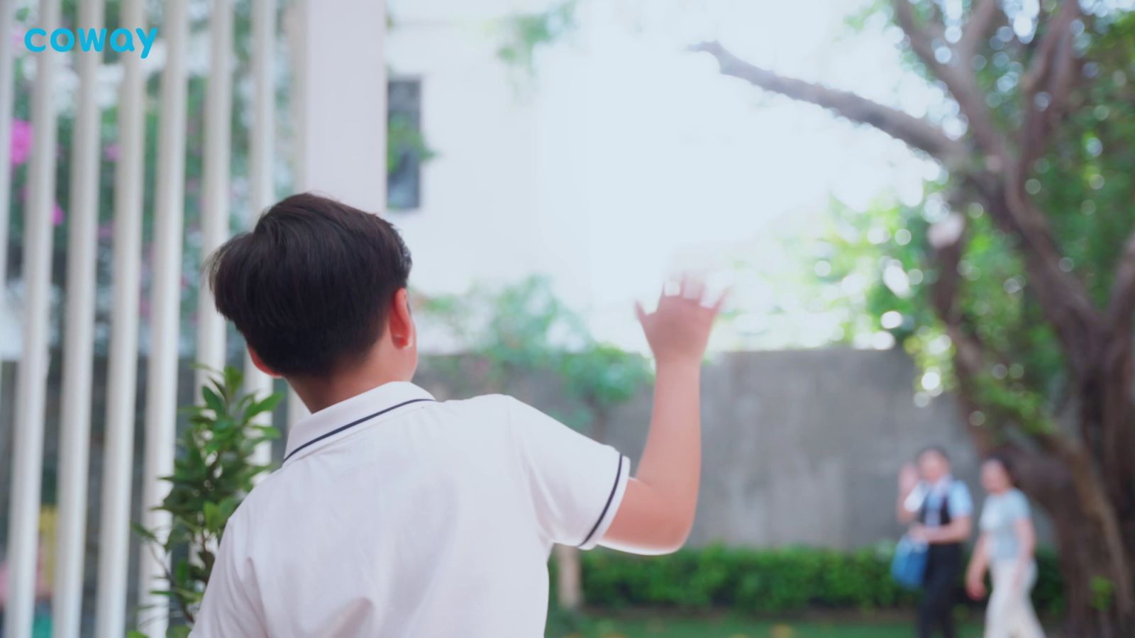 a boy in a white shirt is throwing a frisbee