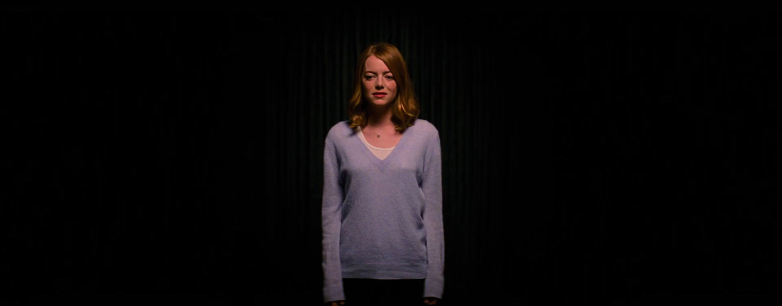 a woman standing in front of a black background