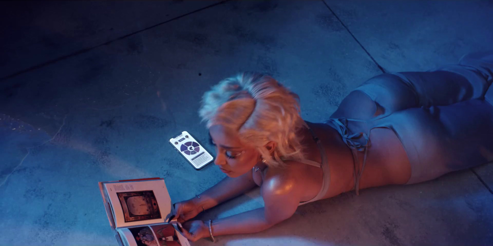 a woman laying on the ground looking at a box