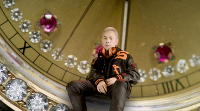 a man sitting on top of a large clock