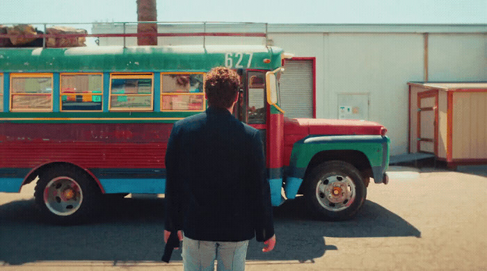 a man standing in front of a colorful bus