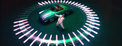 a woman standing in front of a green car