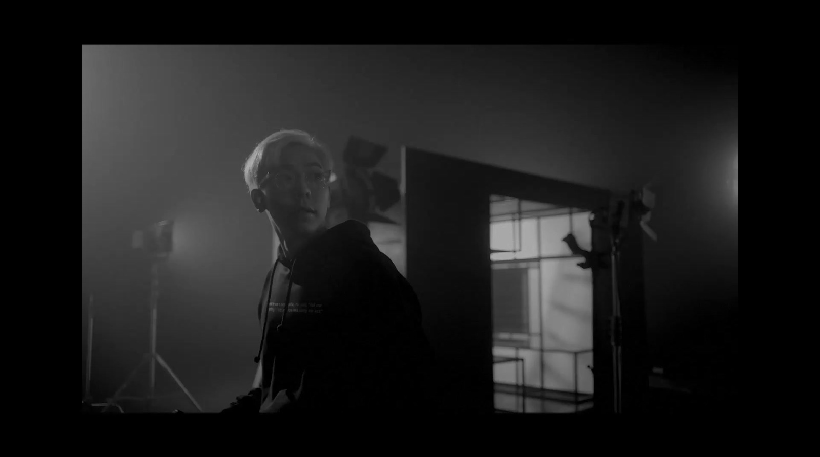 a black and white photo of a man in a dark room