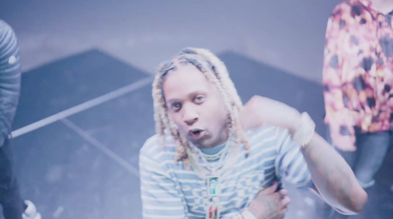 a man with dreadlocks standing in front of a group of people