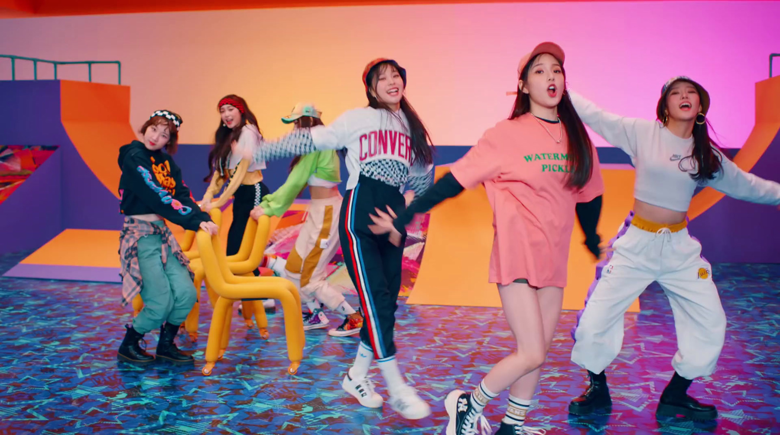 a group of young women standing on top of a blue floor