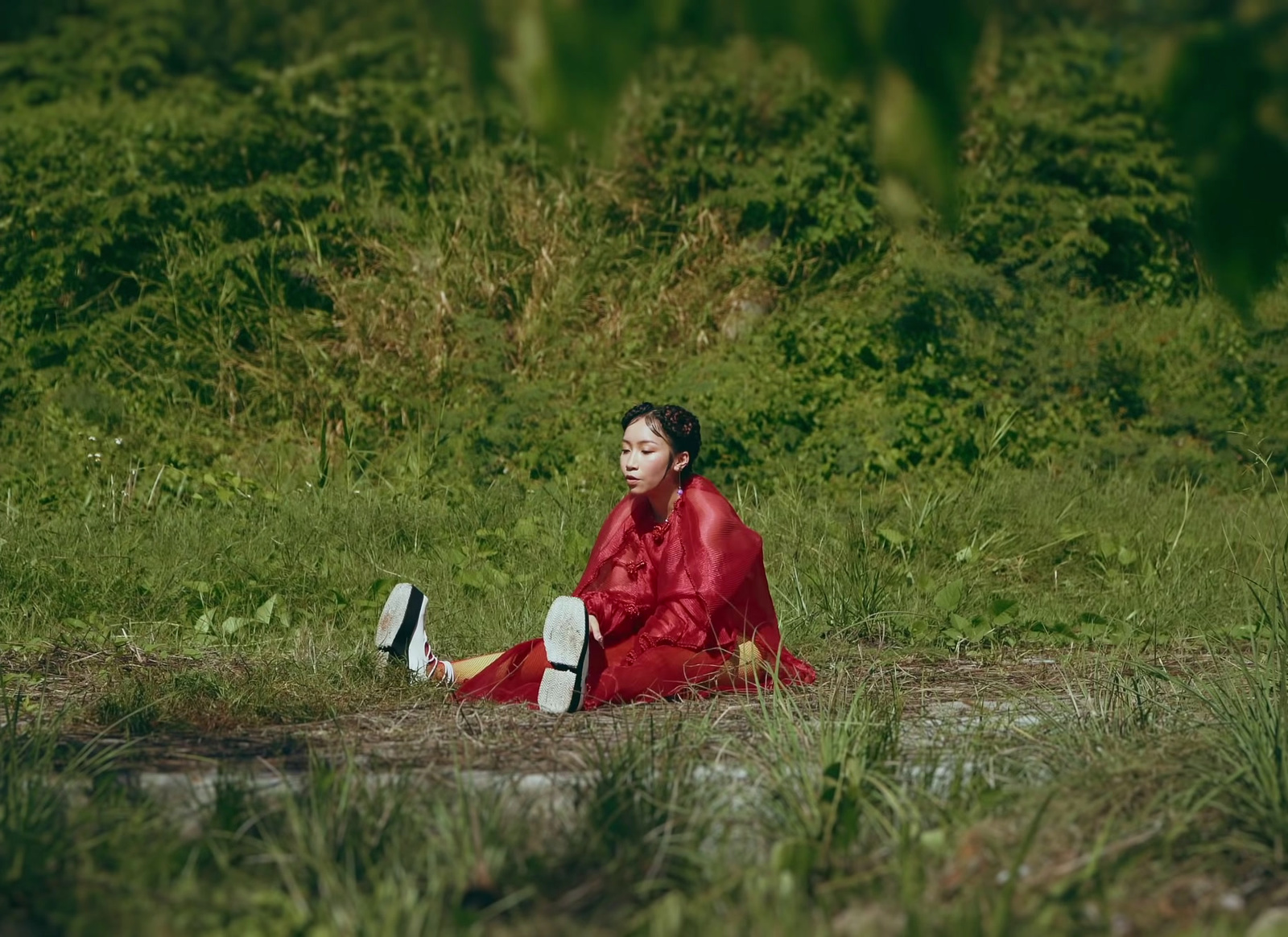 a woman in a red dress sitting on the ground