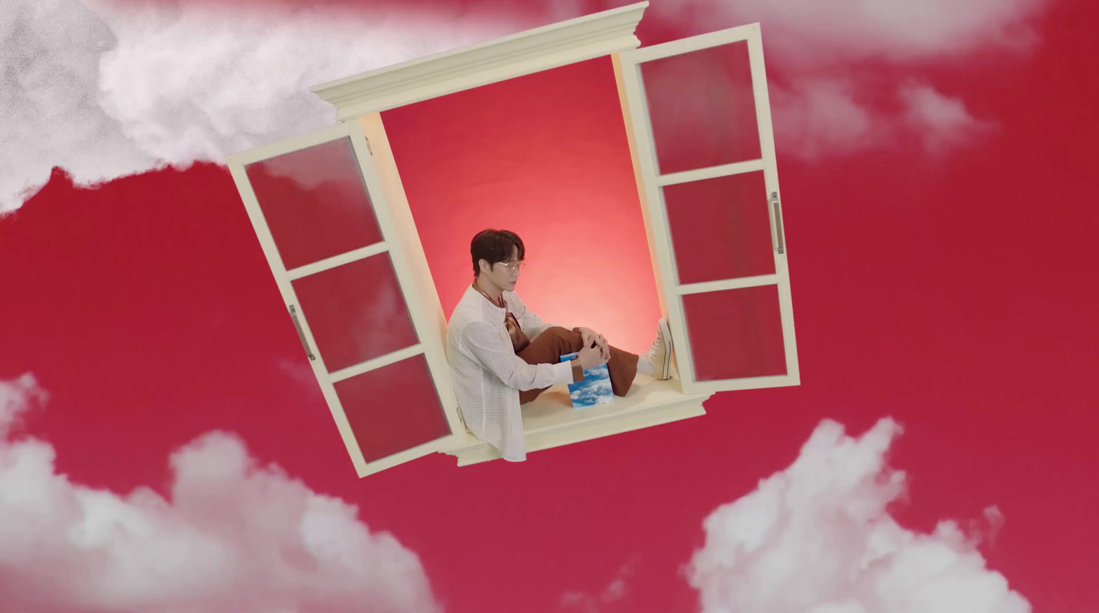 a man sitting on a window sill in the sky