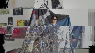 a man wearing sunglasses standing in front of a picture of himself