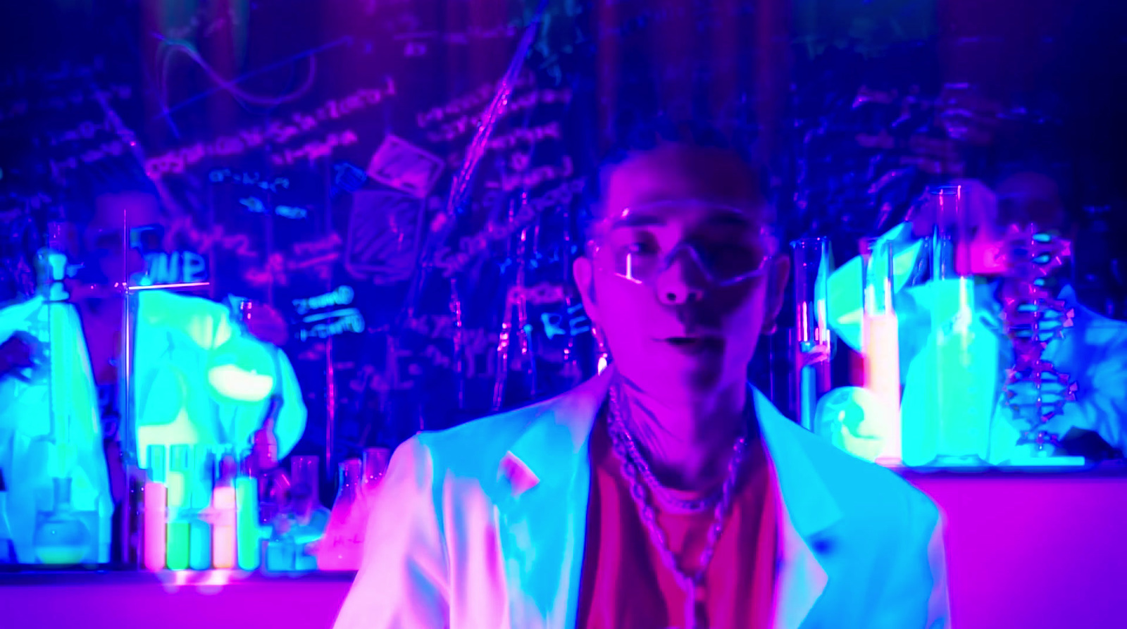 a man in a white jacket and glasses in a room with neon lights