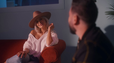 a woman sitting on a red couch talking to a man