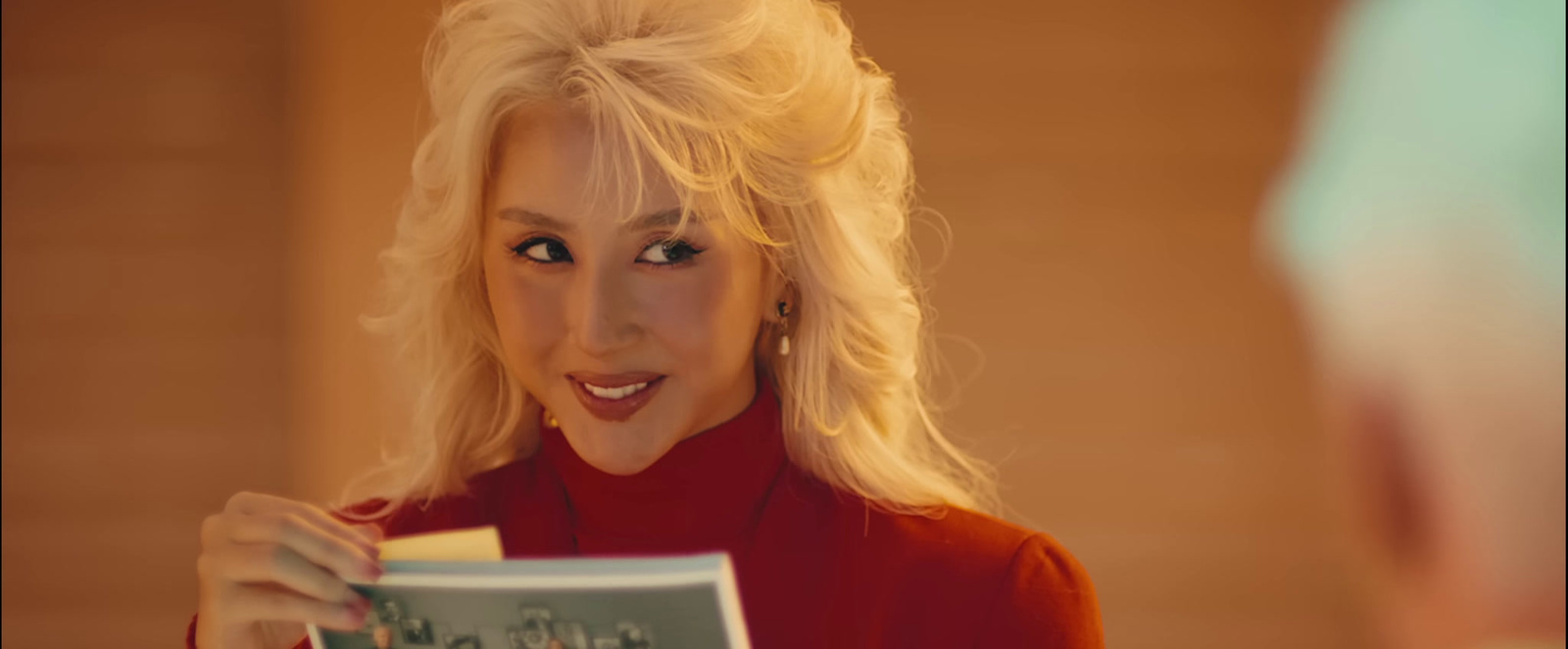 a woman in a red shirt holding a book