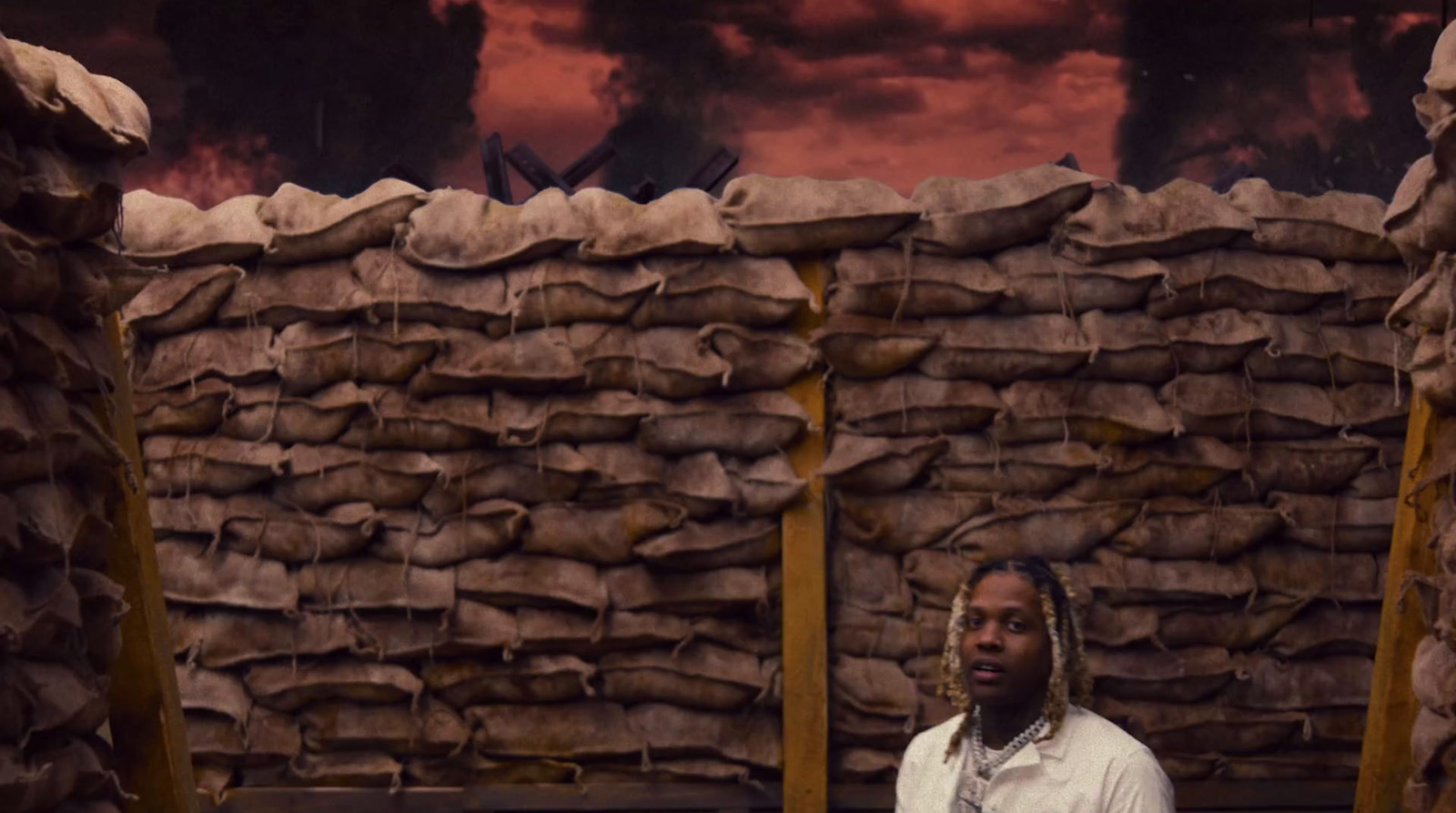 a man standing in front of a pile of sand bags