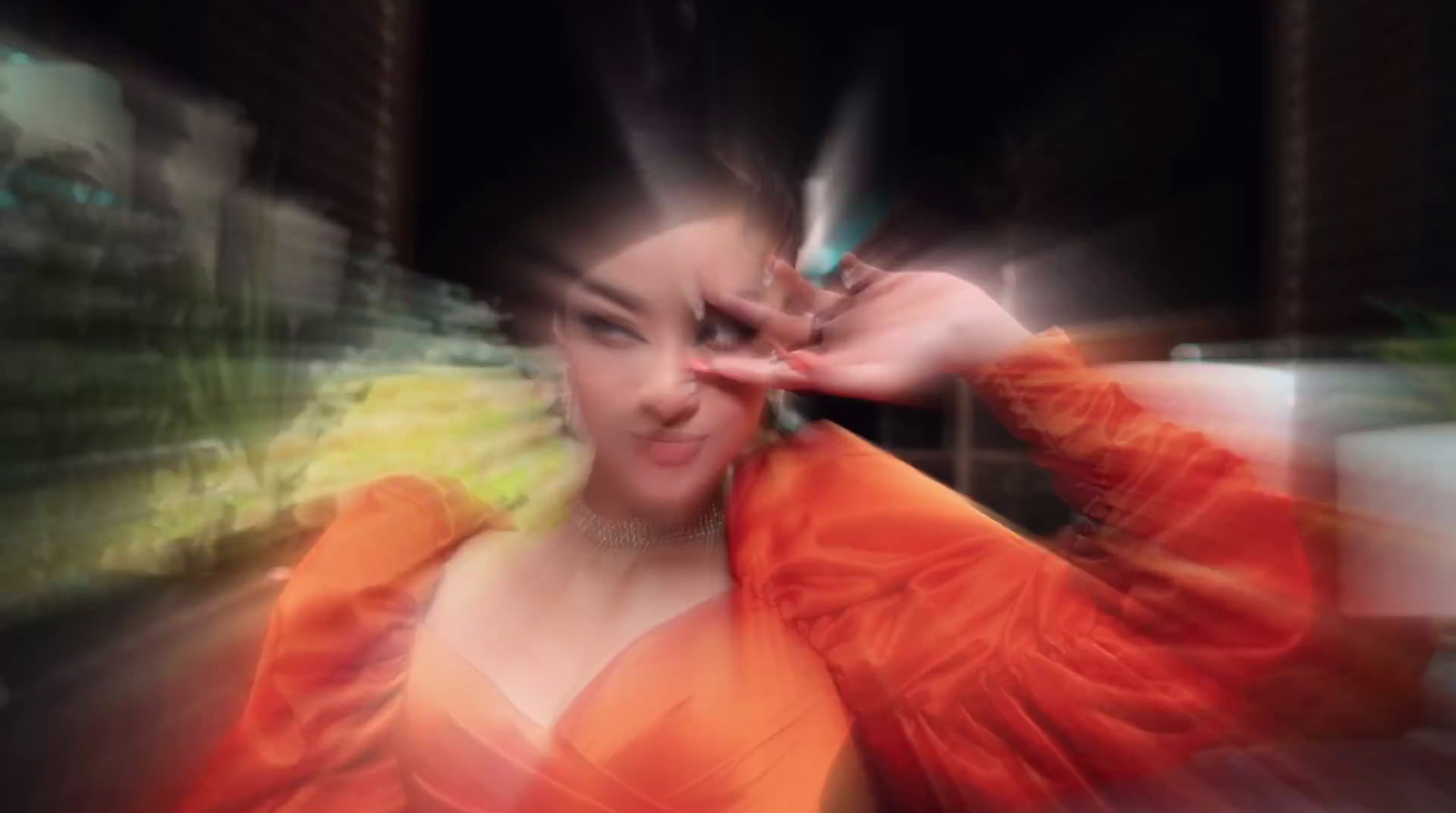 a blurry photo of a woman in an orange dress