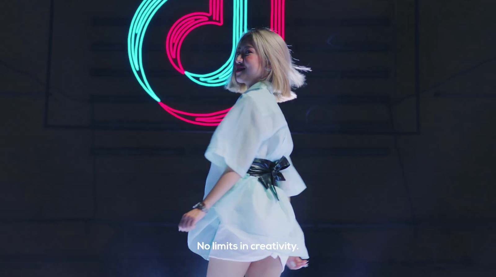 a woman standing in front of a neon sign