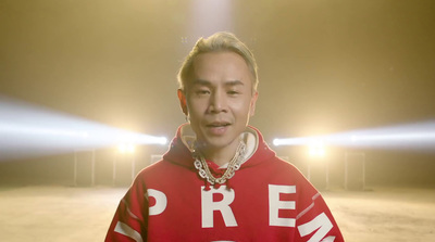 a man in a red hoodie standing in a parking lot