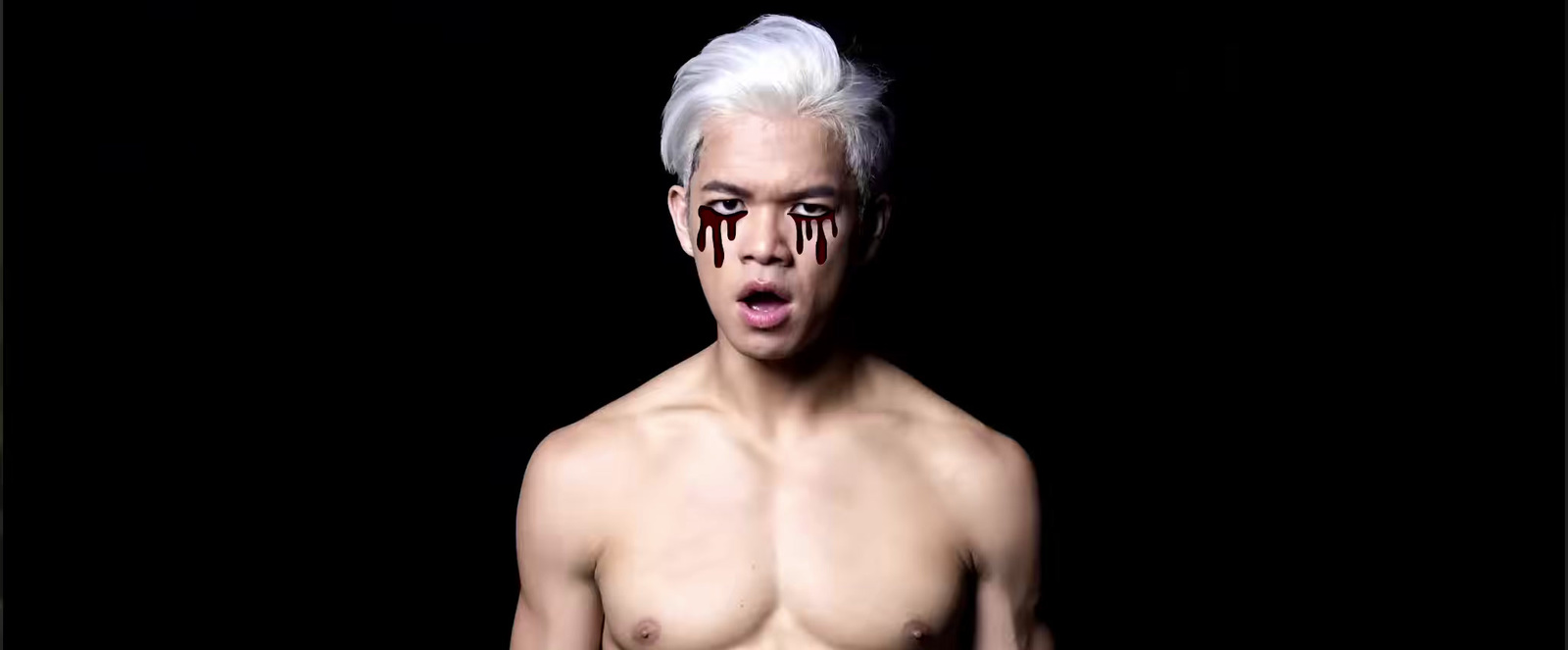 a shirtless man with white hair and dripping blood on his face