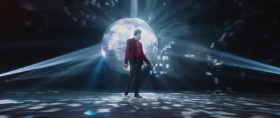 a man standing in front of a disco ball