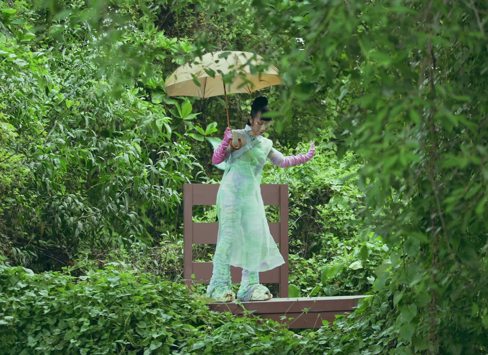 a woman standing on a bench holding an umbrella