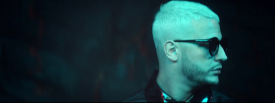 a man with white hair and sunglasses in a dark room