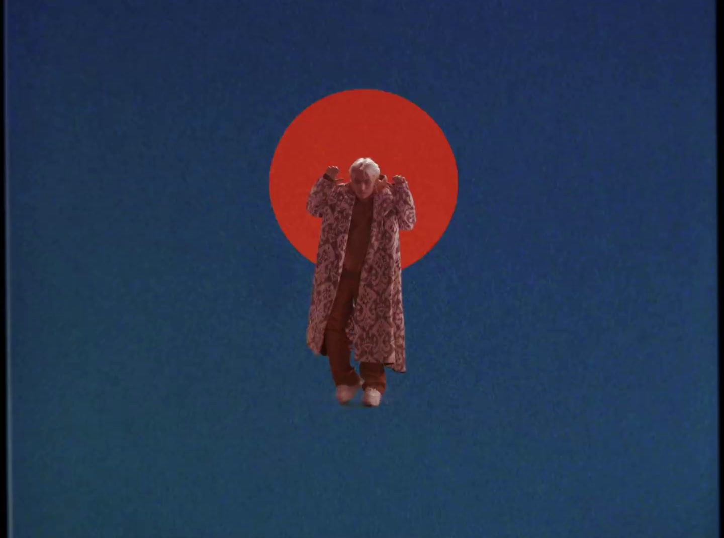 a person standing in front of a red sun