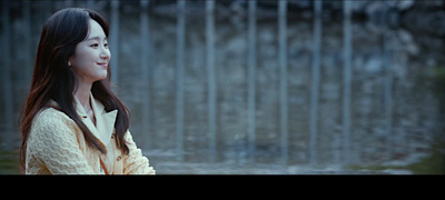 a woman standing in front of a metal fence