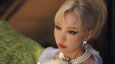 a close up of a doll wearing pearls and pearls