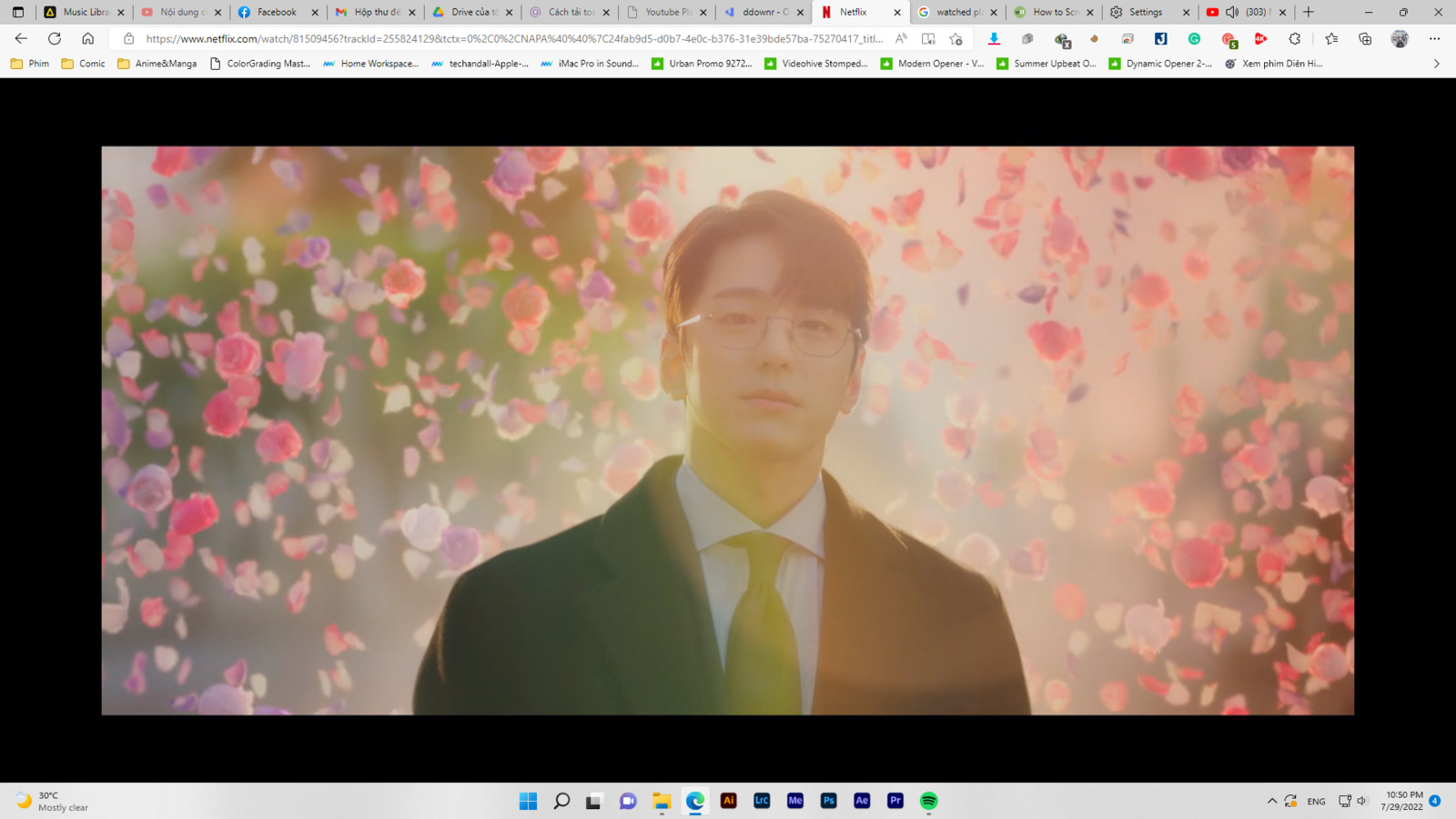 a man in a suit and tie standing in front of flowers