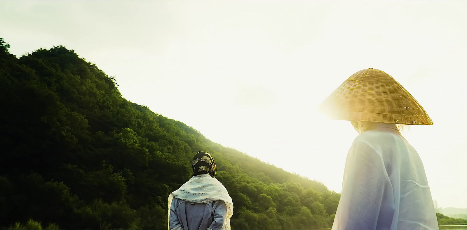 a person with a straw hat and a body of water