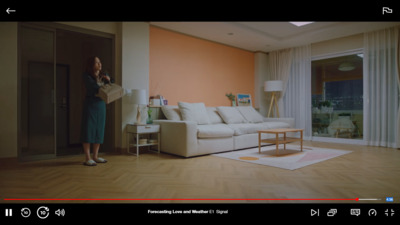 a woman standing in a living room next to a white couch