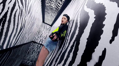 a young boy standing in front of a zebra print wall