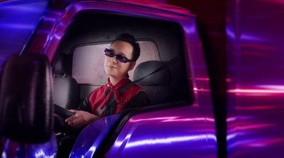 a man in a red shirt driving a purple truck