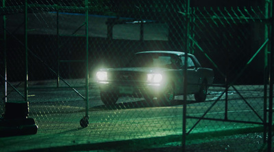 a car driving down a street at night