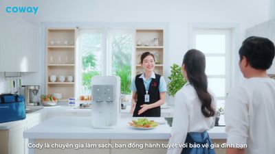 a woman standing in a kitchen with a plate of food