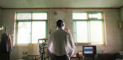 a man standing in front of a window in a room