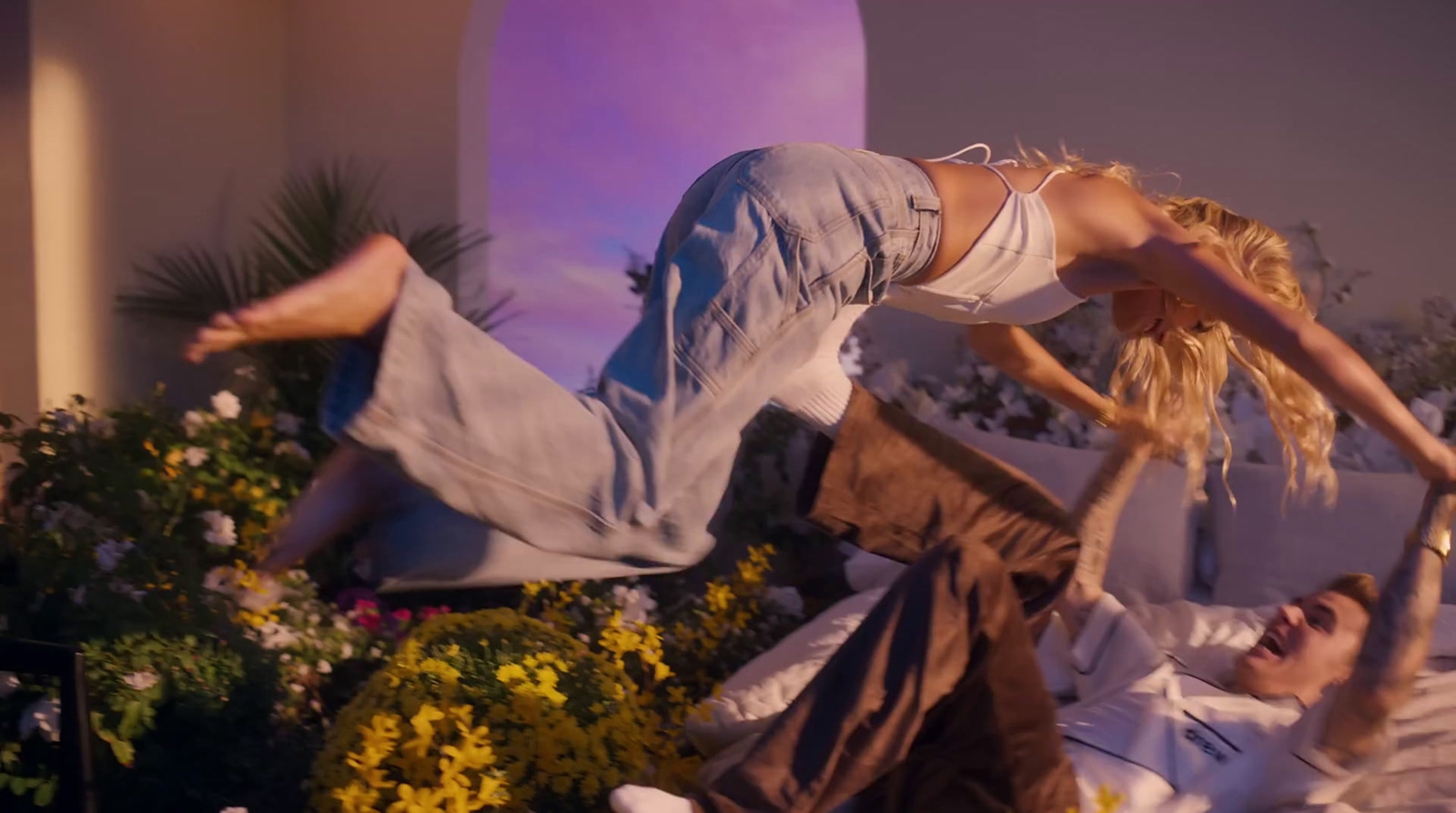 a man and a woman doing a handstand on a bed