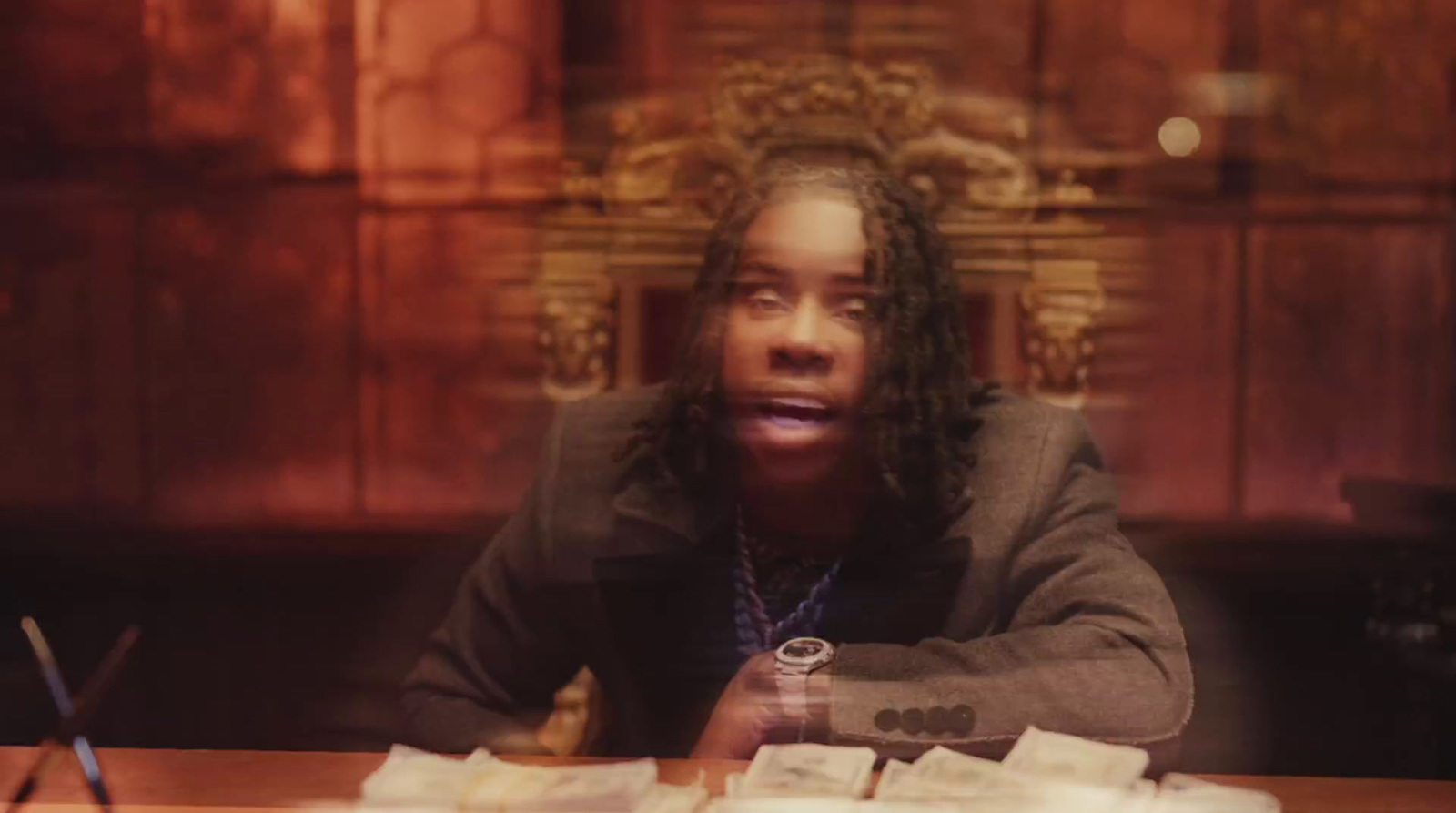 a man sitting at a table with stacks of money