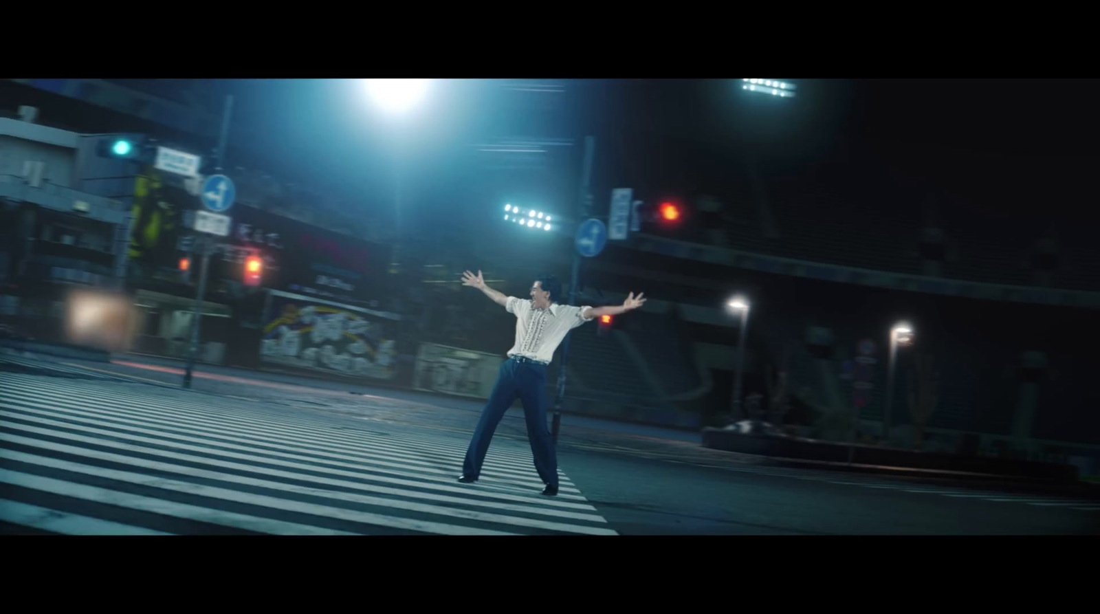 a man standing in the middle of a street at night