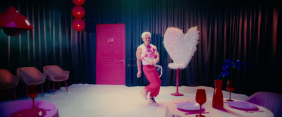 a woman standing in front of a pink door