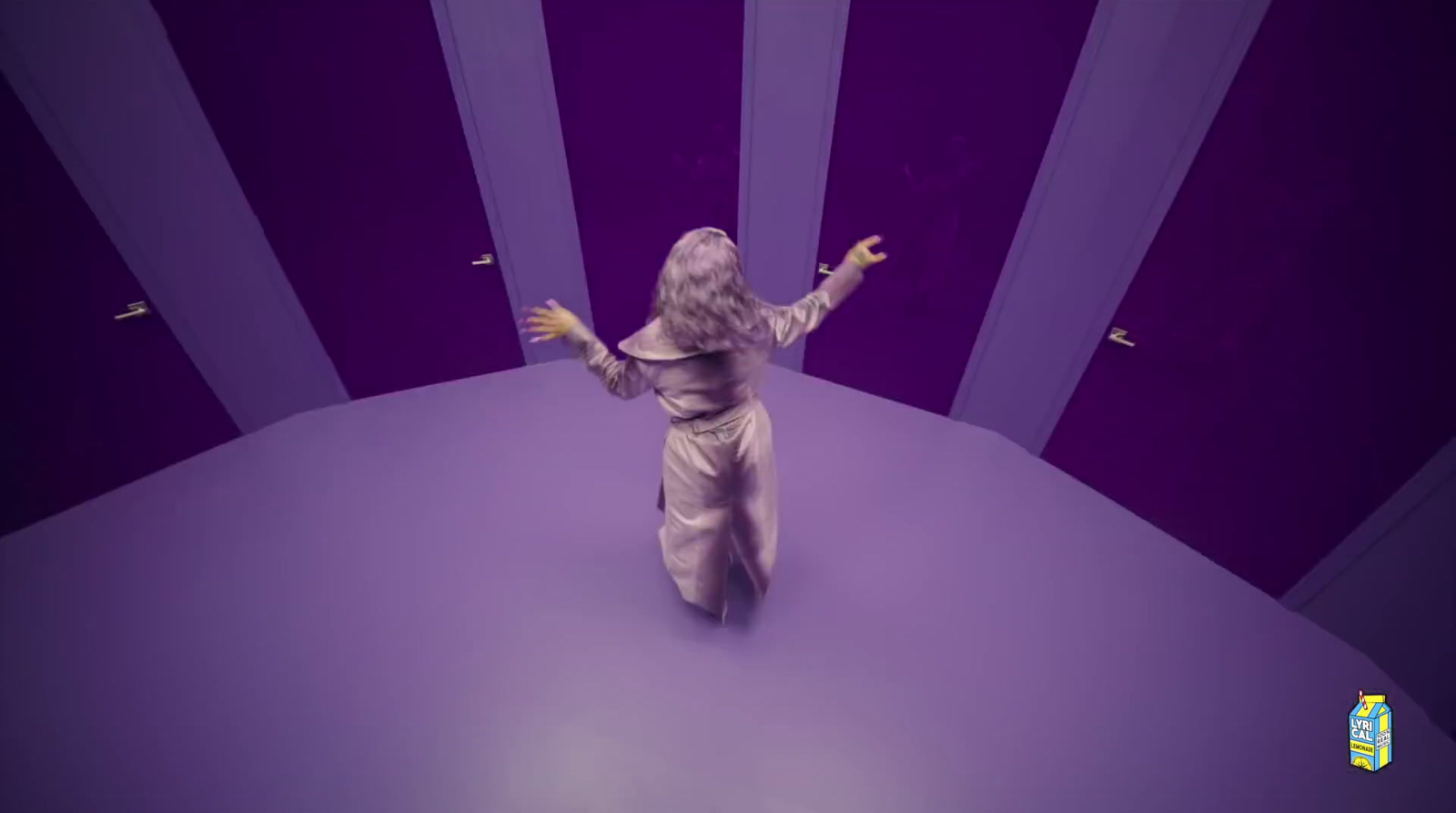 a little girl standing in a room with purple walls