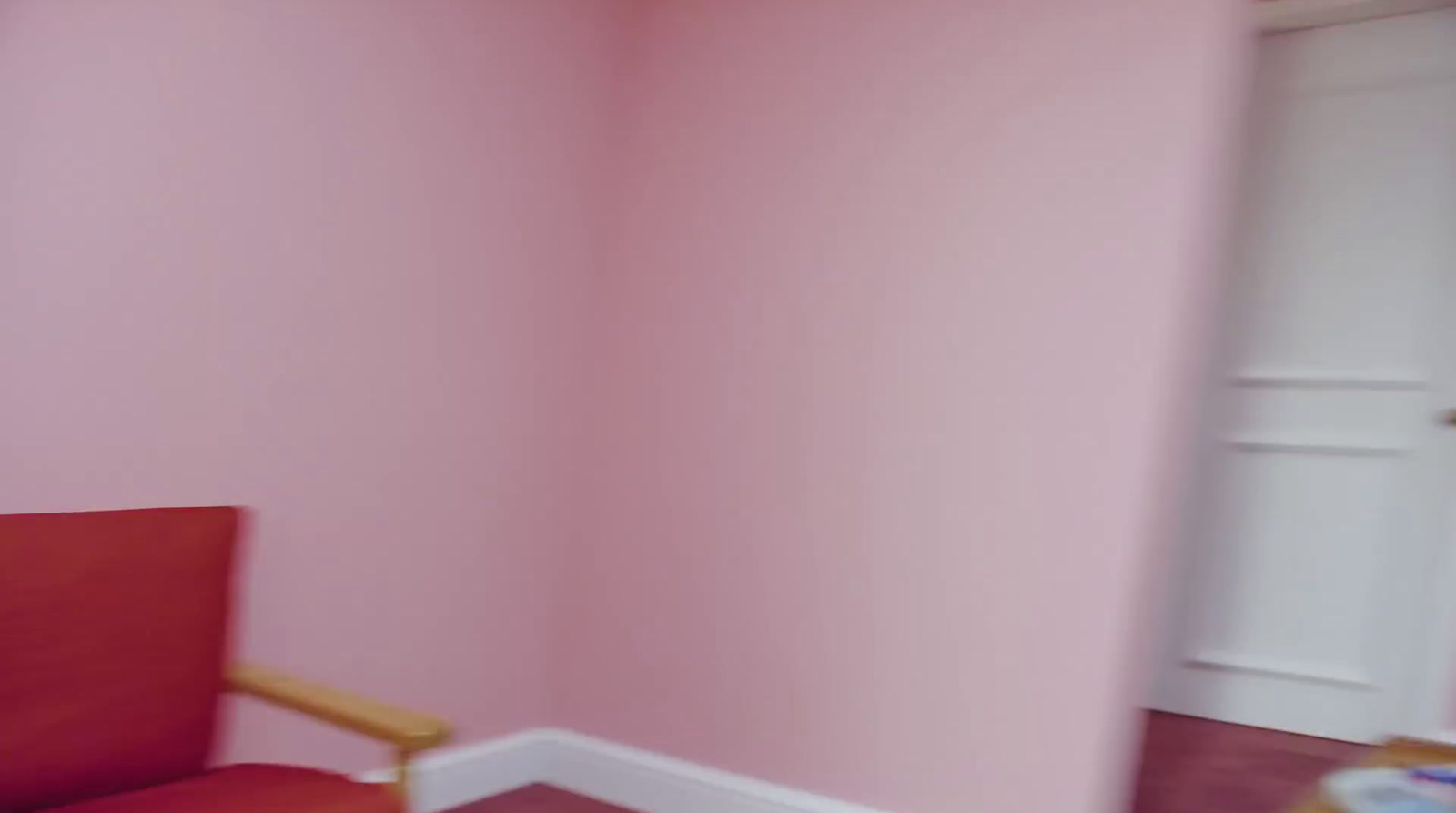 a red chair sitting in a corner of a room