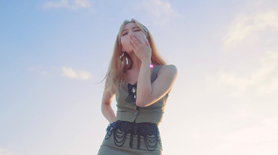 a woman in a short dress covers her face with her hands