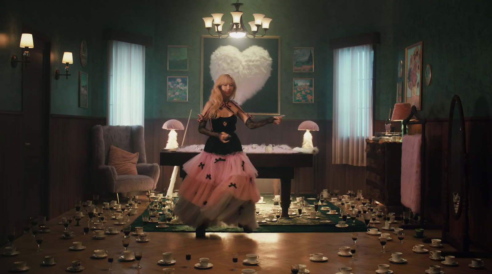 a woman standing in a room full of tea cups