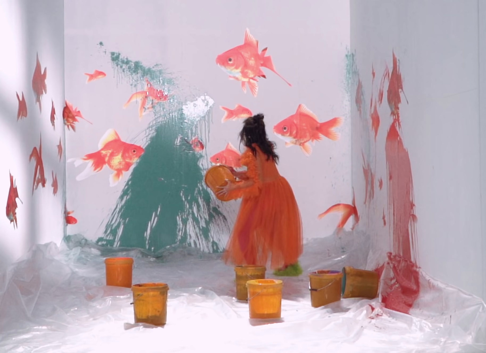 a little girl in an orange dress standing in a room