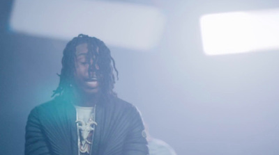 a man with dreadlocks standing in a room