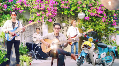 a man sitting on a stool playing a guitar